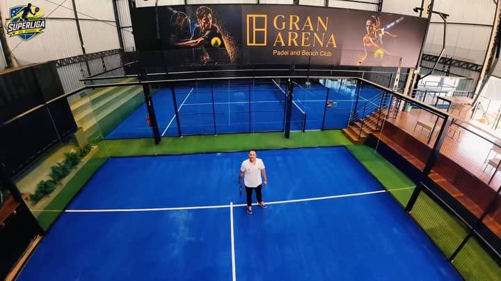 Quadra de padel coberta com o painel da Gran Arena ao fundo